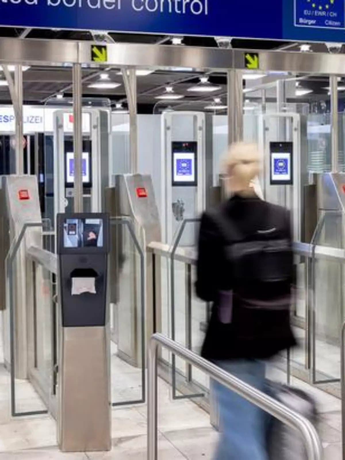 Traveler walking through automated border control gates at an airport